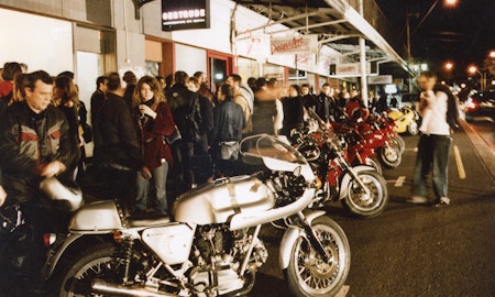 Audiences attend Simone LeAmon, MOTO Showroom, with performance riders from the Moto Guzzi motorcycle club, presented at Gertrude Contemporary Art Spaces, 2003. Courtesy of the artist and the Gertrude Archive.