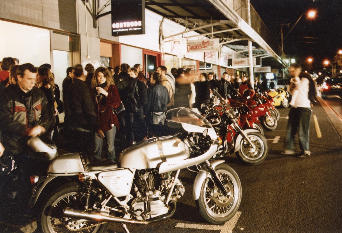 Audiences attend Simone LeAmon, MOTO Showroom, with performance riders from the Moto Guzzi motorcycle club, presented at Gertrude Contemporary Art Spaces, 2003. Courtesy of the artist and the Gertrude Archive.