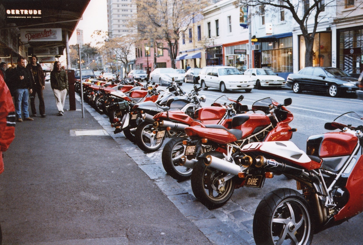 Audiences attend Simone LeAmon, MOTO Showroom, with performance riders from the Moto Guzzi motorcycle club, presented at Gertrude Contemporary Art Spaces, 2003. Courtesy of the artist and the Gertrude Archive.