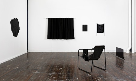 Arthur Nyakuengama, Indoors, leather and steel armchair, shoulder-length latex gloves, latex polish, curtains. 2021. Courtesy and copyright the artist.