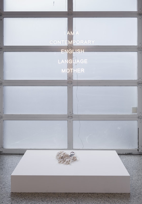 Chunxiao Qu, I AM A CONTEMPORARY ENGLISH LANGUAGE MOTHER, 2025, LED neon with transparent acrylic frames, 80 x 73.39 cm; and Wig Shoes No. 2, Balenciaga shoes, synthetic wig, 30 x 8 x 10 cm, courtesy of the artist and FUTURES, Naarm Melbourne, installation view, Gertrude Glasshouse, Naarm Melbourne, 2025, photography: Christian Capurro