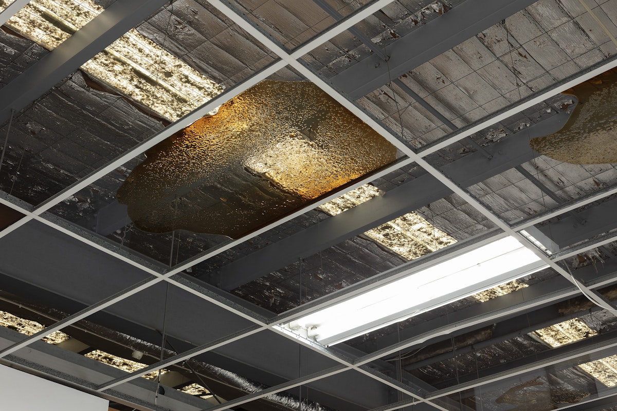 Foster Berean, Lower Expectations, 2025, installation view, Of Stadiums and Construction Sites (Ne change rien pour que tout soit différent), Gertrude Contemporary, Naarm Melbourne, 2025, ceiling panels, bourbon, coke, image courtesy and © the artists, photograph: Christian Capurro