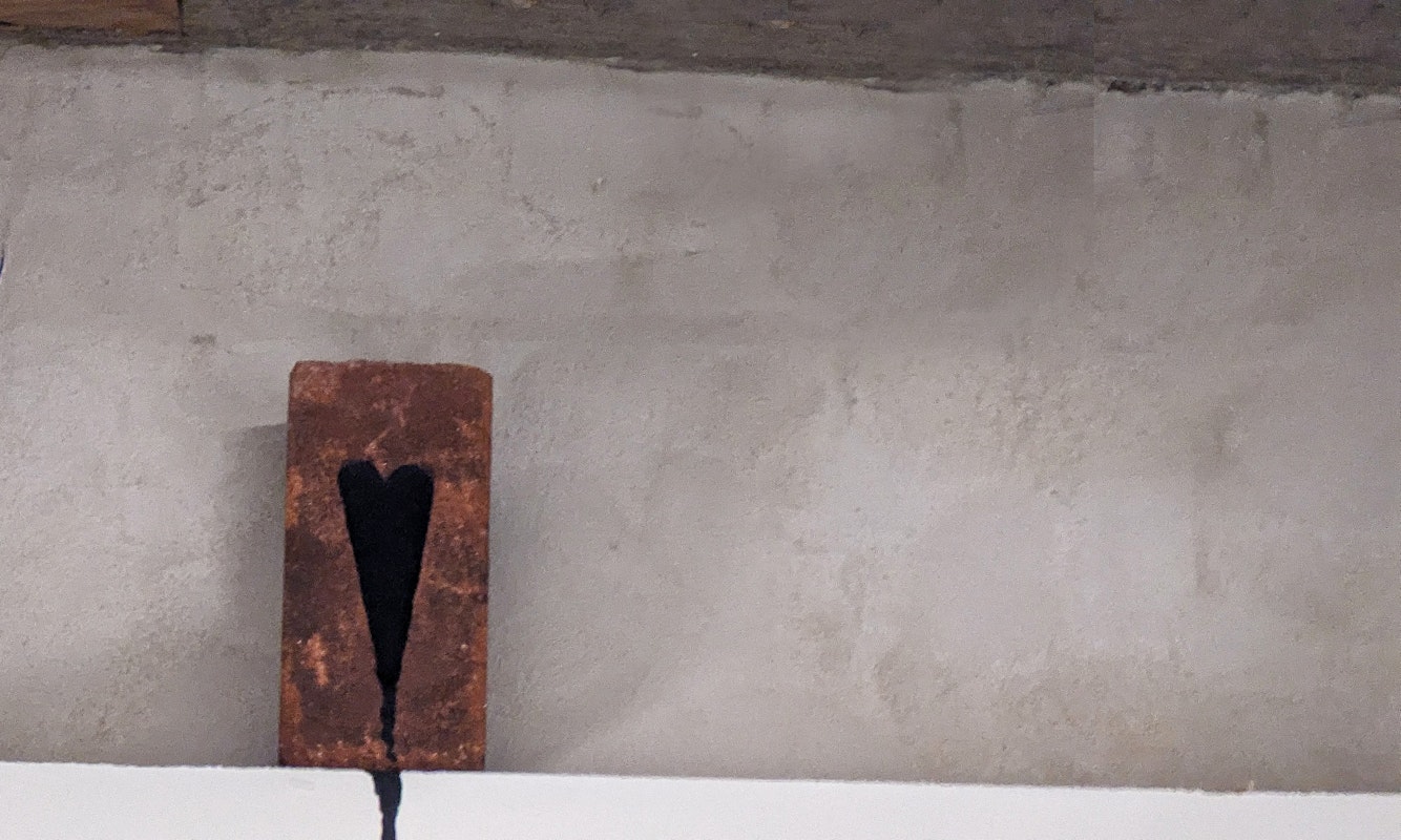Daisy Collier, Bleeding Heart, 2024, installation view, Bus Projects, Naarm Melbourne, 2024, red brick, black tradex paint, pain, image courtesy and © the artist, photograph: Daisy Collier