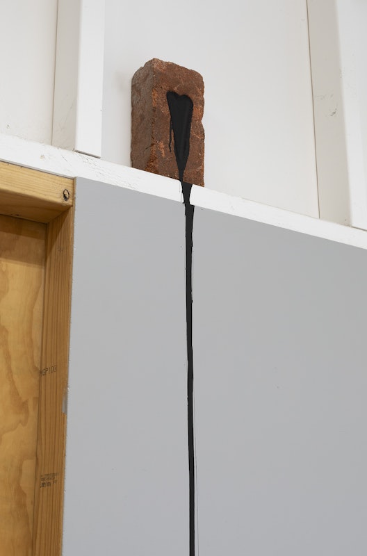 Daisy Collier, Bleeding Heart, 2024, installation view, Bureaucracy of Feelings, Gertrude Contemporary, Naarm Melbourne, red brick, black tradex paint, pain, image courtesy and © the artist, photograph: Christian Capurro