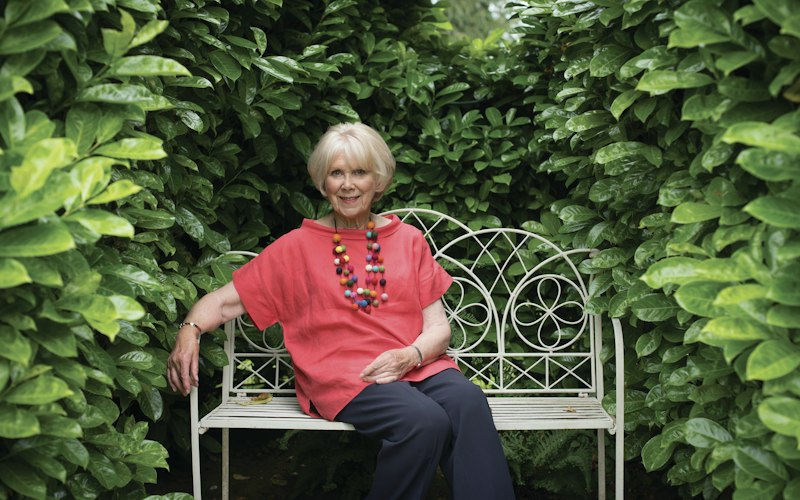 Wendy Craig sitting on a bench