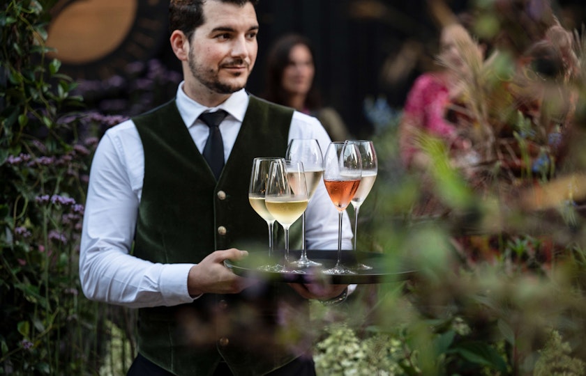 Waiter holding a tray of glasses at a garden party