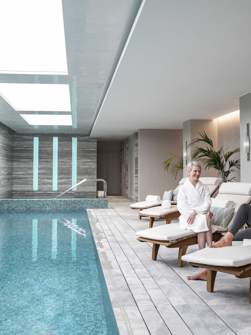 Women relaxing next to pool
