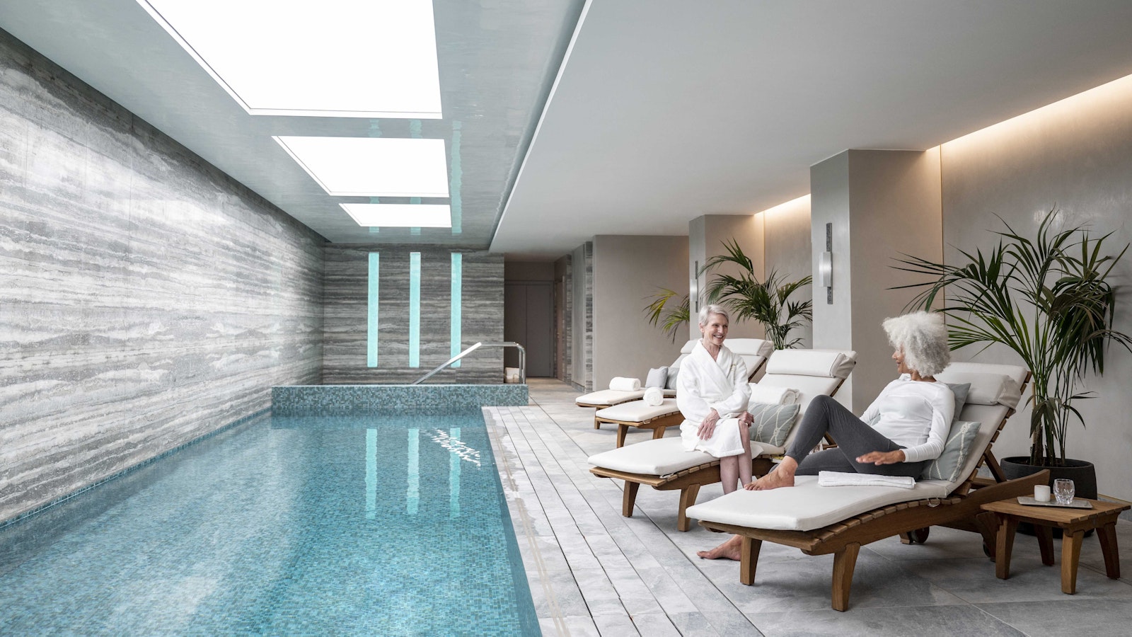 Women relaxing next to pool
