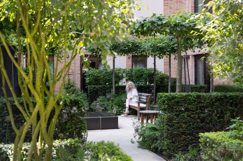 Woman reading in the courtyard garden at Auriens