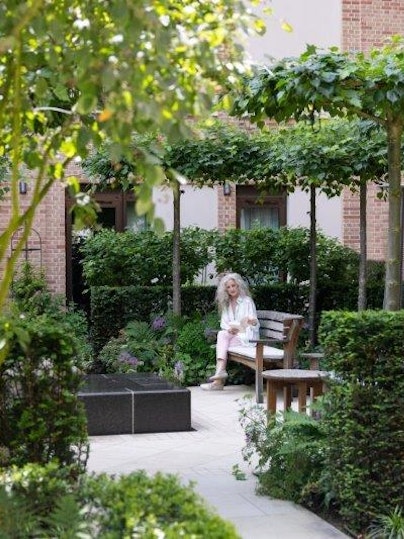 Woman reading in the courtyard garden at Auriens