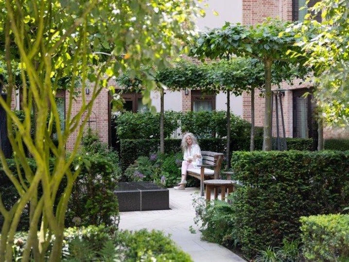 Woman reading in the courtyard garden at Auriens