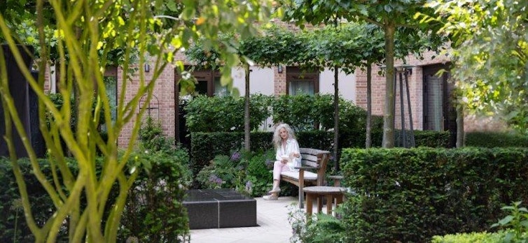 Woman reading in the courtyard garden at Auriens