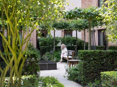 Woman reading in the courtyard garden at Auriens