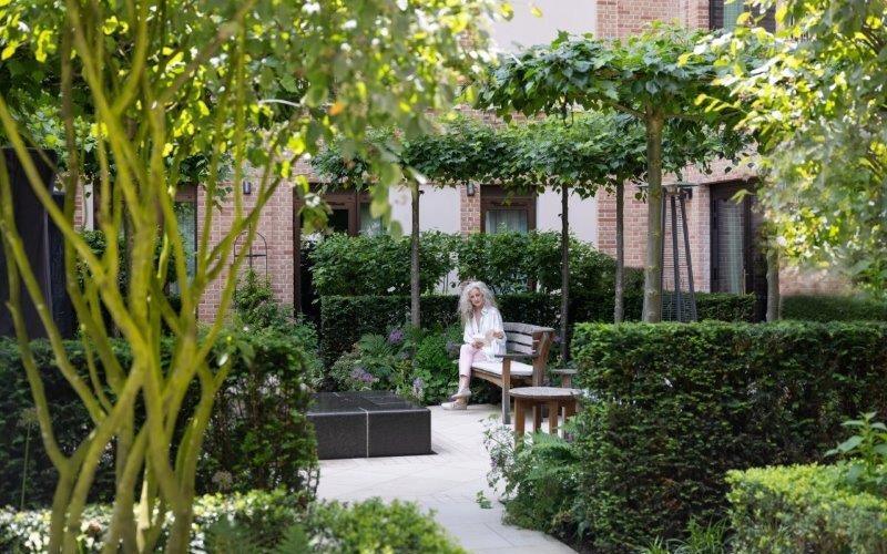 Woman reading in the courtyard garden at Auriens
