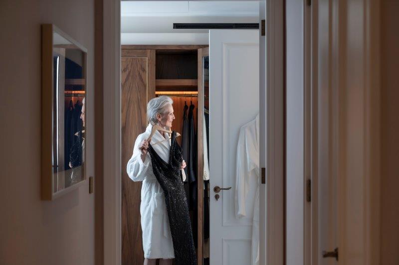 Lady in dressing gown holding up a dress