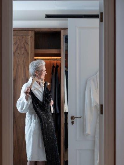 Lady in dressing gown holding up a dress