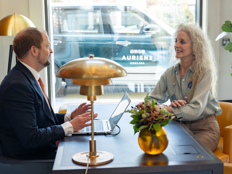 Woman sitting at concierge desk speaking to the Head of Concierge