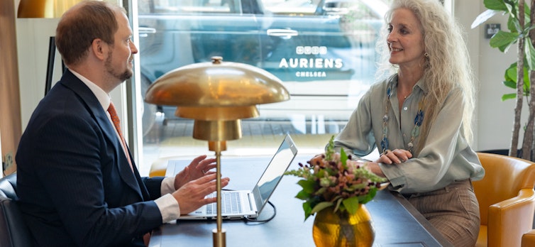 Woman sitting at concierge desk speaking to the Head of Concierge