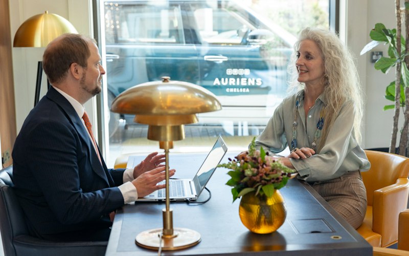 Woman sitting at concierge desk speaking to the Head of Concierge