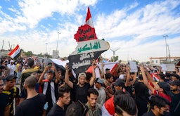 متظاهرون عراقيون يحيون الذكرى السنوية الأولى لحركة الاحتجاج الواسعة التي طالب فيها الشارع العراقي بتحسين الخدمات العامة، والإصلاحات ووضع حد للفساد المستشري. النجف، العراق. 25 أكتوبر/تشرين الأول 2020 (الصورة عبر غيتي إيماجز)
