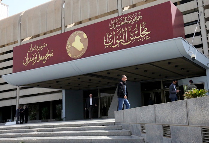 عراقيون يقفون خارج مبنى البرلمان في المنطقة الخضراء ببغداد، 27 فبراير/شباط 2020 (الصورة عبر غيتي إيماجز)