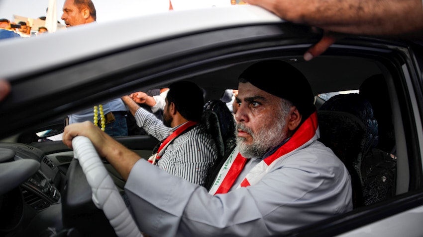 Iraqi cleric Muqtada Al-Sadr drives a car as he joins anti-government demonstrators gathering in the holy city of Najaf on Oct. 29, 2019. (Photo via Getty Images)