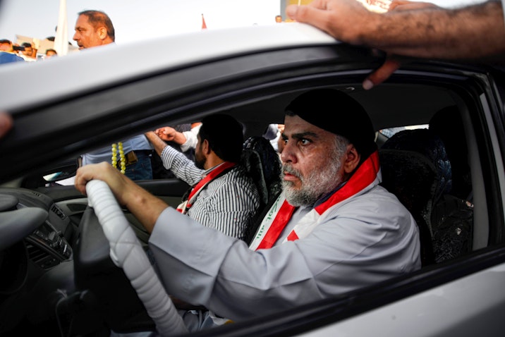 Iraqi cleric Muqtada Al-Sadr drives a car as he joins anti-government demonstrators gathering in the holy city of Najaf on Oct. 29, 2019. (Photo via Getty Images)