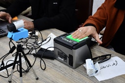 مرأة عراقية تحدّث سجلها الإنتخابي في الناصرية بمحافظة ذي قار في 12 يناير /كانون الثاني 2021 (الصورة عبر غيتي إيماجز)