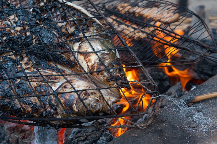 Photo taken on Nov. 3, 2018 showing grilled fish known as Masgouf cooked over an open fire in the southern marshes of Iraq. (Photo via Getty Images)