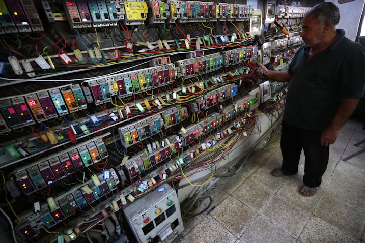 An Iraqi man checks an electric generator supplying homes with electricity in Baghdad, Iraq on July 26, 2018. (Photo via Getty Images)