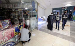 رجال الشرطة يطبقون إجراءات تتعلق بفيروس كوفيد -19 في مدينة الكويت في 10 فبراير/شباط 2021 (الصورة عبر غيتي إيماجز)