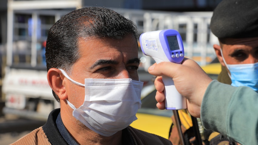 Health officials perform a routine temperature screening in Baghdad, Iraq on Feb. 22, 2021 (Photo via Getty Images)