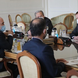 وزير الخارجية الإيراني (إلى اليسار) يلتقي بالمدير العام للوكالة الدولية للطاقة الذرية (يمين) في طهران في 21 فبراير/شباط 2021 (الصورة عبر غيتي إيماجز)