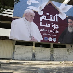 لوحة إعلانات تحمل صورة البابا فرنسيس وآية الله العظمى علي السيستاني في بغداد، العراق. في 3 مارس/آذار 2021 (الصورة عبر غيتي إيماجز)