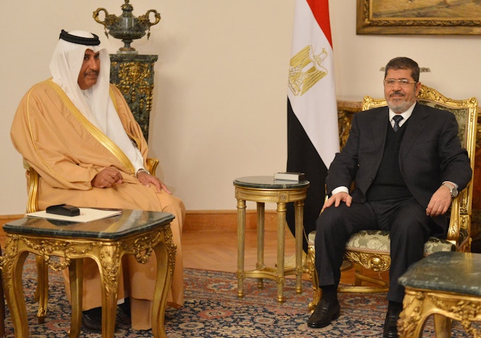 الرئيس المصري محمد مرسي يلتقي وزير الخارجية القطري حمد بن جاسم آل ثاني في القاهرة في 8 يناير/كانون الثاني عام 2013 (الصورة عبر غيتي إيماجز).