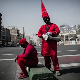 دو مرد در لباس حاجی فیروز در خیابانی در تهران، پایتخت ایران.  ۲۷ اسفند ۱۳۹۸. (عکس از زهره سلیمی از خبرگزاری آنا)