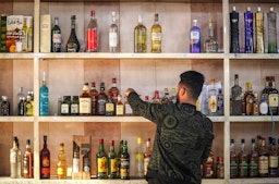 A shopworker arranges liquor bottles at an alcohol shop in the Bataween district of Iraq's capital Baghdad on Dec. 5, 2020. (Photo via Getty Images)