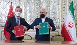  Iran’s foreign minister (right) and his Chinese counterpart pose for a photo after signing a 25-year cooperation agreement in Tehran. (Photo by Mohammadreza Abbasi via Mehr News Agency)