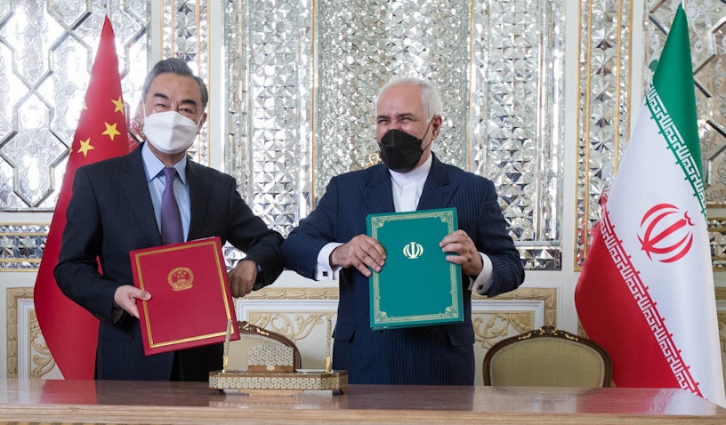  Iran’s foreign minister (right) and his Chinese counterpart pose for a photo after signing a 25-year cooperation agreement in Tehran. (Photo by Mohammadreza Abbasi via Mehr News Agency)