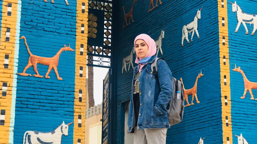 Young Iraqi archeologist Raya Nassif at a replica of the Ishtar Gate in Babylon, Iraq. (Photo via author)