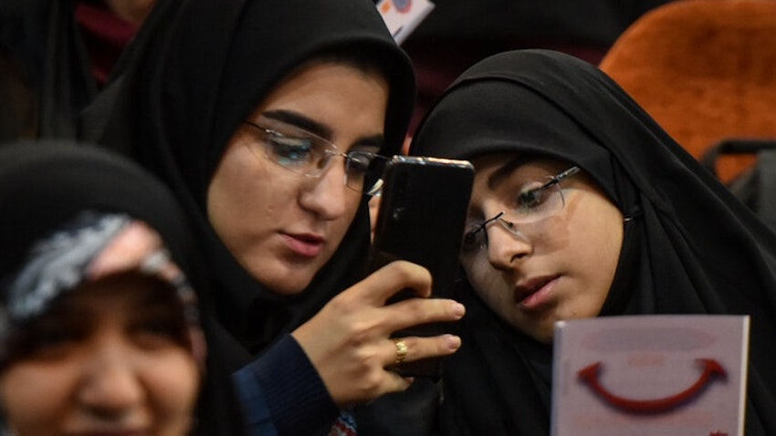 طالبتان إيرانيتان تنظران إلى هاتف محمول خلال مؤتمر في جامعة العلامة الطباطبي. طهران، ايران. 7 ديسمبر/كانون الأول 2019 (تصوير بهنام توفقي فروهر عبر وكالة مهر الإخبارية)