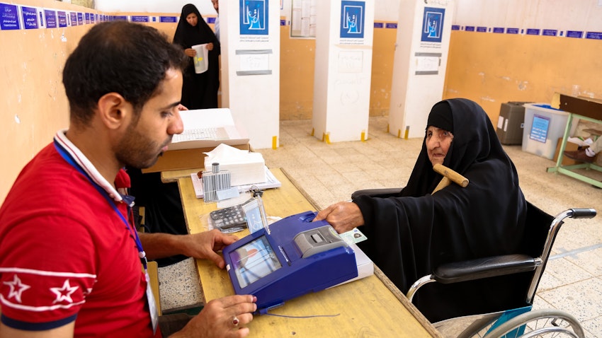 فحص بطاقة التصويت البيومترية الخاصة بامرأة عراقية في النجف، العراق. 12 مايو/ أيار 2018 (الصورة عبر غيتي إيماجز)