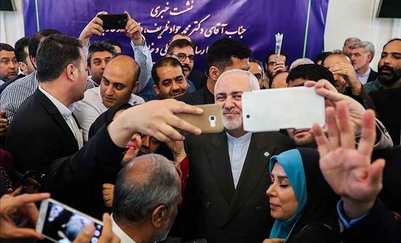 Iran's Foreign Minister Mohammad Javad Zarif poses for selfies with reporters as he leaves a press conference in Tehran on Aug. 5, 2019. (Photo by Hamed Malekpour via Tasnim News Agency)