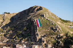 A Kurdish flag is placed on a mountain in Duhok governorate, Iraq on March 18, 2021. (Photo via Getty Images).
