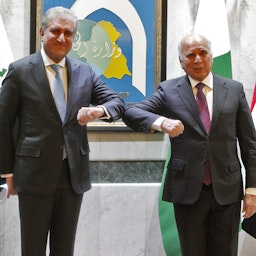 وزير الخارجية الباكستاني شاه محمود قريشي (إلى اليسار) يقف لالتقاط صورة مع نظيره العراقي فؤاد حسين في بغداد، العراق. 29 مايو/ أيار 2021 (الصورة عبر غيتي إيماجز)