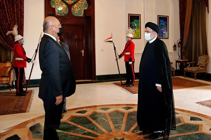 رئيس المحكمة العليا في إيران آنذاك إبراهيم رئيسي (إلى اليمين) يلتقي الرئيس العراقي برهم صالح في بغداد. 10 فبراير/ شباط 2021 (الصورة من وكالة ميزان للأنباء)