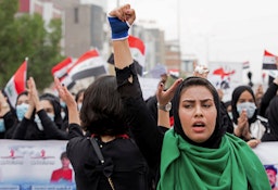 إمرأة عراقية ترفع قبضتها خلال الاحتجاجات المناهضة للحكومة في البصرة. 2 ديسمبر/ كانون الأول 2019 (الصورة عبر غيتي إيماجز)