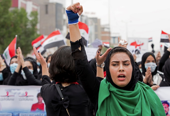 إمرأة عراقية ترفع قبضتها خلال الاحتجاجات المناهضة للحكومة في البصرة. 2 ديسمبر/ كانون الأول 2019 (الصورة عبر غيتي إيماجز)