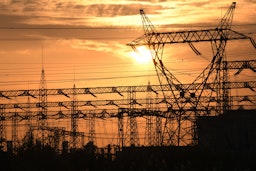 The sun sets behind electrical grids in the southern Iraqi city of Nasiriyah on Jan. 3, 2021. (Photo via Getty Images)