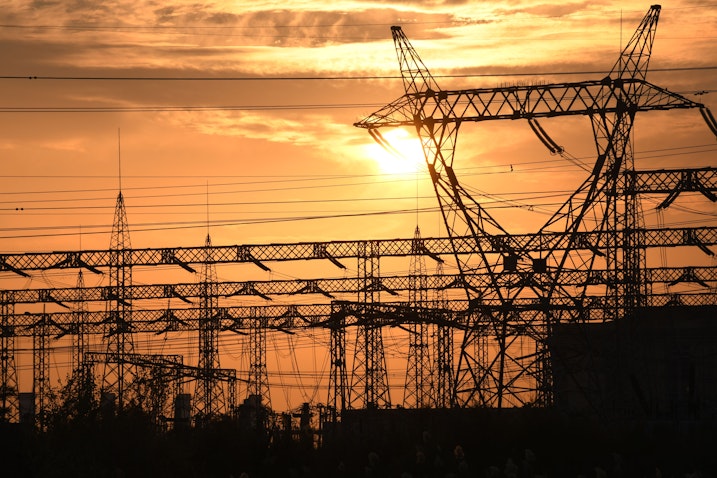 The sun sets behind electrical grids in the southern Iraqi city of Nasiriyah on Jan. 3, 2021. (Photo via Getty Images)